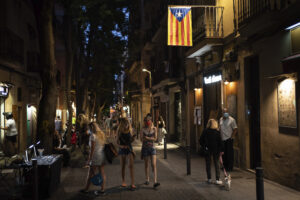 People walk at night in Gracia neighborhood in Barcelona, Spain, Friday, July 24, 2020. Health authorities in the northeastern region of Catalonia have ordered nightclubs to be fully closed and bars and restaurant in Barcelona to shut down by midnight in an effort to stem the spread of the new coronavirus. (AP Photo/Felipe Dana)