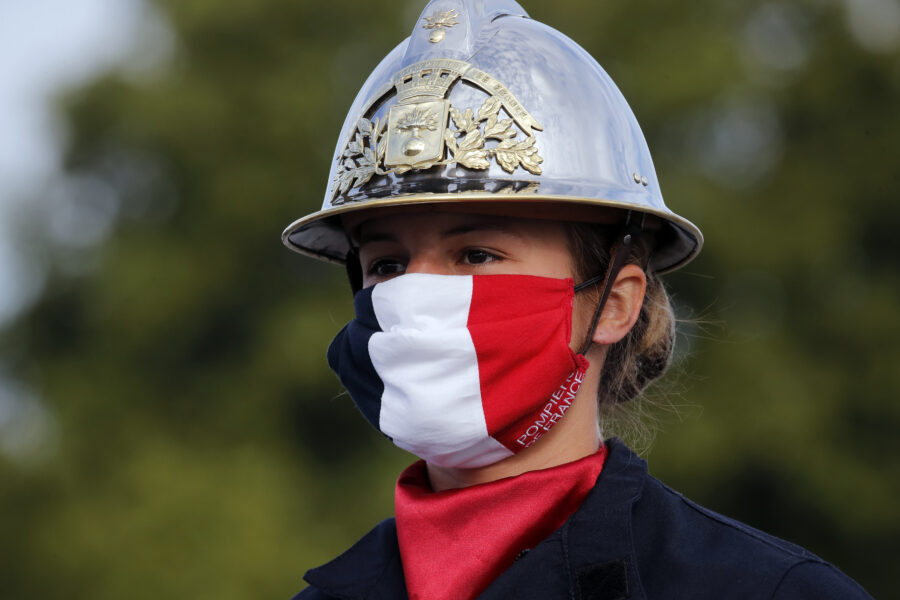 A firefighter wears a face mask with the colors of the French flag, prior to the Bastille Day parade Tuesday, July 14, 2020 on the Champs Elysees avenue in Paris. France are honoring nurses, ambulance drivers, supermarket cashiers and others on its biggest national holiday Tuesday. Bastille Day’s usual grandiose military parade in Paris is being redesigned this year to celebrate heroes of the coronavirus pandemic. (AP Photo/Christophe Ena, Pool)