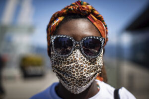 Maayaa Quist-Adade wears a face covering and sunglasses decorated with hearts during the coronavirus pandemic as she attends an Emancipation Day March, in Vancouver, on Saturday, Aug. 1, 2020. Emancipation Day marks the abolition of slavery in parts of the British Empire. The Slavery Abolition Act went into effect on August 1, 1834, after receiving Royal Assent nearly a year earlier. (Darryl Dyck/The Canadian Press via AP)