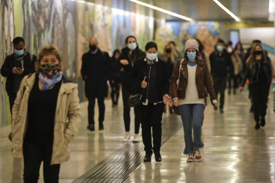 People wear masks to prevent the spread of COVID-19 as they walk in the underground of the Garibaldi railway station, in Milan, Italy, Tuesday, Oct. 13, 2020. Italian Premiere Giuseppe Conte ordered strict new anti-COVID measures early Tuesday, including limits on private gatherings and a ban on casual pickup sports. (AP Photo/Luca Bruno)