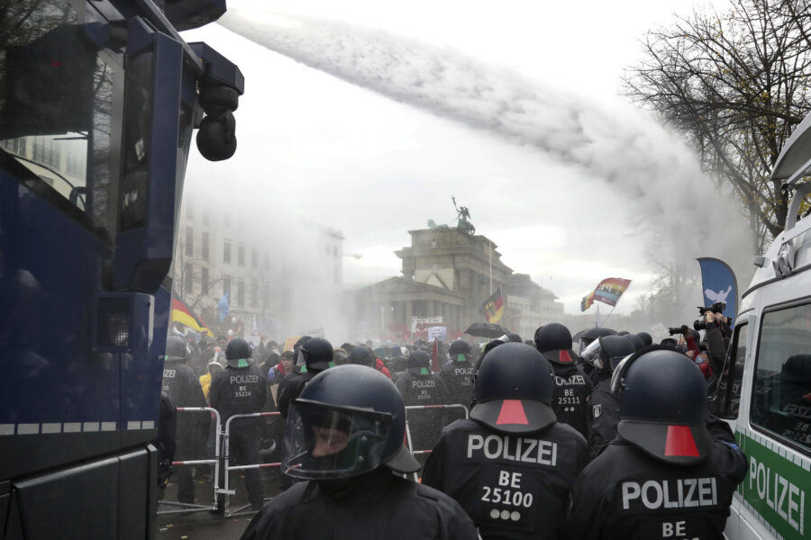 Police uses water canons to clear a blocked a road between the Brandenburg Gate and the Reichstag building, home of the German federal parliament, as people attend a protest rally in front of the Brandenburg Gate in Berlin, Germany, Wednesday, Nov. 18, 2020 against the coronavirus restrictions in Germany. Police in Berlin have requested thousands of reinforcements from other parts of Germany to cope with planned protests by people opposed to coronavirus restrictions. (AP Photo/Michael Sohn)