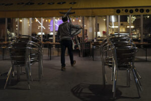 Philippe Cotonnec of the Atalante Bar carries tables to close a bar terrace in Paris, Monday Sept. 28, 2020. French President Emmanuel Macron justified on Monday new restrictions in the country to limit the spread of the virus as restaurant and bar owners forced to shut down expressed anger at the measures. Milder restrictions have been ordered in ten other cities including Paris, with gyms shut down, public gatherings of more than 10 people banned and bars ordered to close at 10 p.m. (AP Photo/Francois Mori)