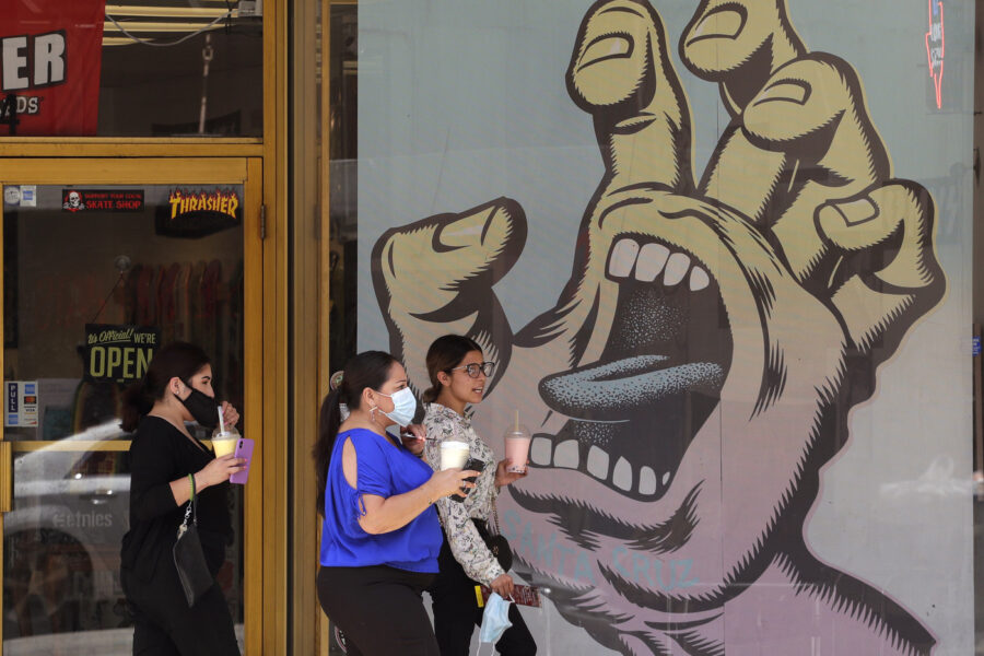 People wearing masks to protect against the spread of COVID-19, pass a mural on a business that has reopened in San Antonio, Wednesday, June 24, 2020, in San Antonio. Cases of COVID-19 have spiked in Texas and the governor of Texas is encouraging people to wear masks in public and stay home if possible. (AP Photo/Eric Gay)
