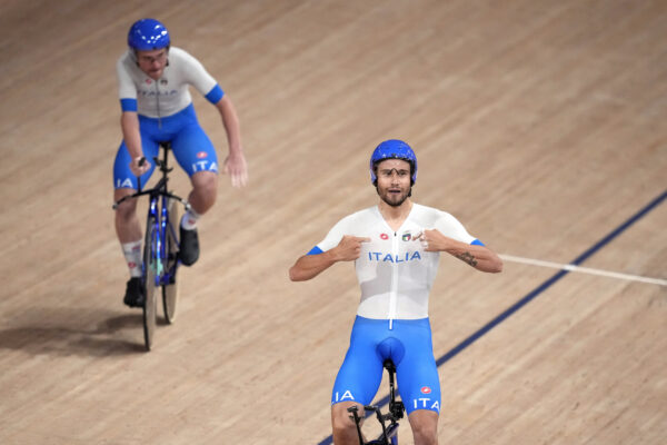 Filippo Ganna, right, and Simone Consonni of Team Italy celebrate after winning their heat during the track cycling men’s team pursuit at the 2020 Summer Olympics, Tuesday, Aug. 3, 2021, in Izu, Japan. (AP Photo/Christophe Ena)