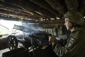 A Ukrainian serviceman of 28th brigade shoots a Maxim gun towards Russian positions at the frontline in Donetsk region, Ukraine, Wednesday, June 21, 2023. (AP Photo/Evgeniy Maloletka)