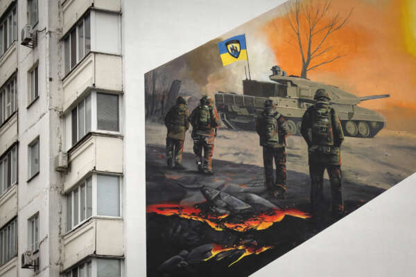 A mural depicts volunteer soldiers of the 3rd assault brigade to honour the memory of their fellow soldier Serhiy Mashovets on an apartment building wall in Kyiv, Ukraine, Thursday, Feb. 1, 2024. Mashovets was killed in 2022 defending capital Kyiv from the Russian troops. He was an ecology activist who wanted to create a natural park in his home city district. (AP Photo/Efrem Lukatsky)