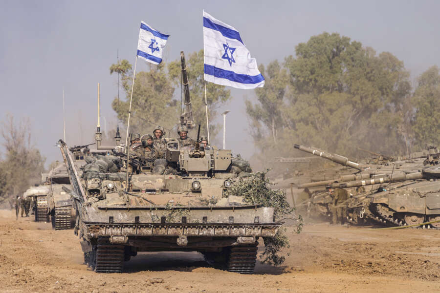 Israeli army vehicles arrive to an staging area after combat in the Gaza Strip in southern Israel, Saturday, Dec. 30, 2023. The army is battling Palestinian militants across Gaza in the war ignited by Hamas’ Oct. 7 attack into Israel. (AP Photo/Tsafrir Abayov)