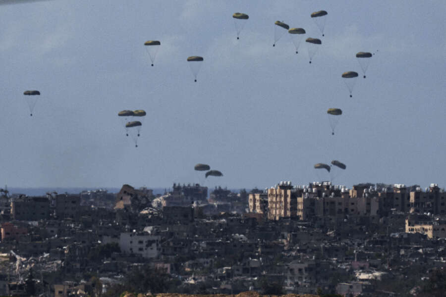 Parachutes drop supplies into the northern Gaza Strip, as seen from southern Israel, Friday, March 8, 2024. (AP Photo/Leo Correa)