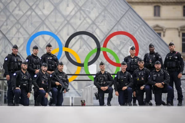 French police pose for a group photo outside the Louvre in Paris, France, during the opening ceremony of the 2024 Summer Olympics, Friday, July 26, 2024. (AP Photo/Ebrahim Noroozi)