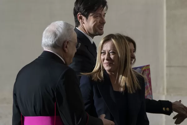 Italian Premier Giorgia Meloni, center, talks to Monsignor Leonardo Sapienza, left, as she arrives with her partner Andrea Giambruno, second from left, and her sister Arianna (partially hidden) at The Vatican, Tuesday, Jan. 10, 2023 for an audience with Pope Francis. (AP Photo/Domenico Stinellis)