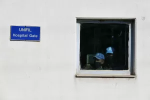 UNIFIL soldiers wear medical masks look from behind a window in the headquarters of the U.N. peacekeeping force in the southern Lebanese border town of Naqoura, Lebanon, Wednesday, Oct. 14, 2020. Lebanon and Israel are to begin indirect talks Wednesday over their disputed maritime border, with American officials mediating the talks that both sides insist are purely technical and not a sign of any normalization of ties. (AP Photo/Bilal Hussein)