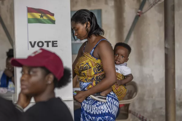 A woman with her child prepares her ballot in the general elections in Accra, Ghana, Saturday, Dec. 7, 2024 (AP Photo/Jerome Delay)